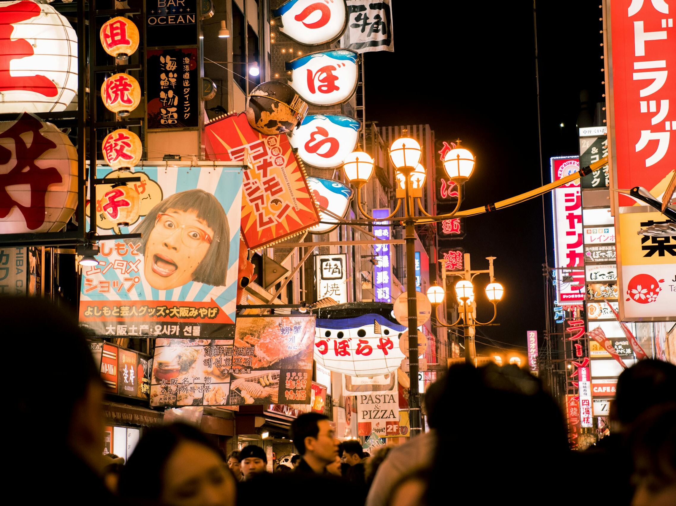 Explore the bustling nightlife of Osaka's Dotonbori street with vivid neon lights and bustling crowds.